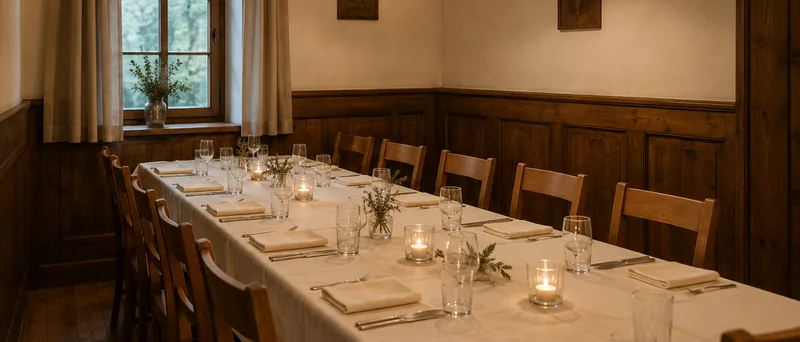 Lange gedeckte Tafel im Nebenzimmer mit Kerzen und Gläsern
